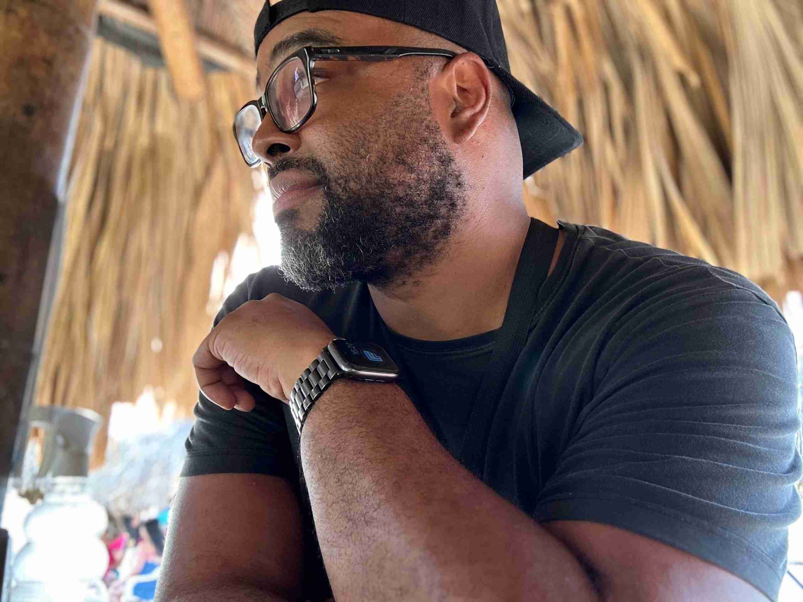 Man with glasses sitting in a thatched hut