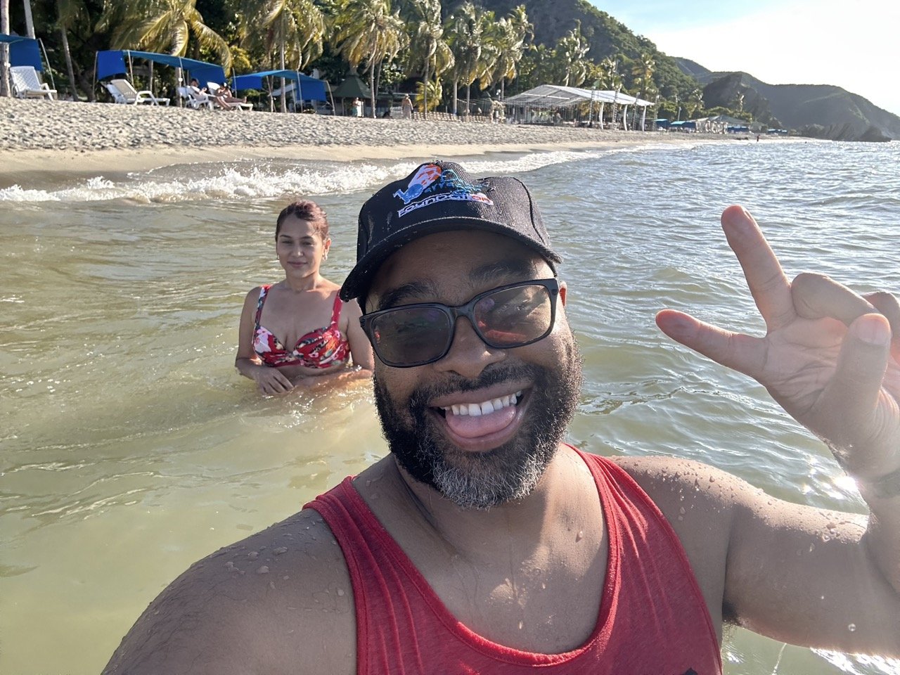 Smiling man and woman in ocean, sunny beach day.